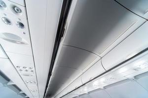 Airplane air conditioning control panel over seats. Stuffy air in aircraft cabin with people. New low-cost airline photo