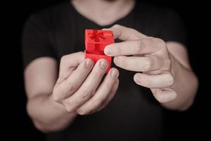 Man give a gift in red gift box on St. Valentine day photo