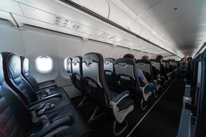 Airplane cabin seats with passengers. Economy class of new cheapest low-cost airlines without delay or cancellation of flight. Travel trip to another country. photo