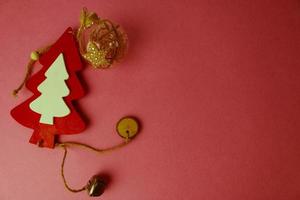 Festive Christmas winter winter happy beautiful pink purple background with a small toy wooden homemade cute Christmas tree. Flat lay. Top view. Holiday decorations photo