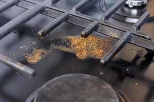 Unclean dirty kitchen black stove after soup boil over, dried food spots, fat stains dry food leftovers photo