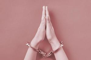Praying hands in handcuffs photo