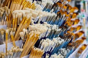 New artistic paint brushes on shelf in stationery shop photo