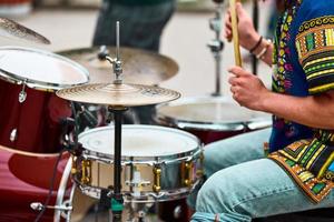 Drummer man playing drums percussion with sticks, drum kit on concert stage, drumsticks and drums photo