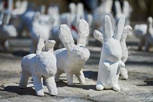 estatuas de conejo blanco hechas de yeso en una exposición de arte al aire libre, graciosas liebres blancas en la calle foto