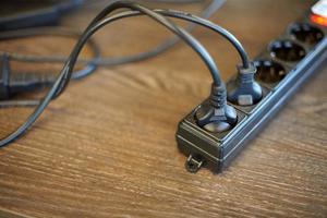 Two plugs plugged into electric power bar. Power supply for computer and monitor. Electrical outlet in which many devices are included photo