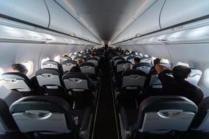 Airplane cabin seats with passengers. Economy class of new cheapest low-cost airlines without delay or cancellation of flight. Travel trip to another country. photo