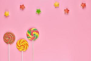 Sweet lollipop and candy on pink background photo