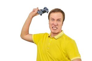 Angry gamer with wireless gamepad dressed in yellow T-shirt isolated on white background photo