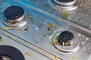 Dirty gas stove with food leftovers and crumbs photo