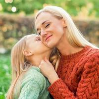 Daughter kisses her young mother photo