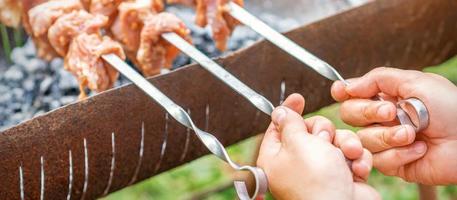 Hands of man prepares barbecue meat photo