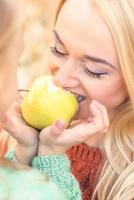Girl with mother eating apple photo