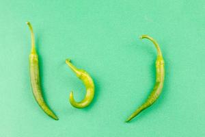 three small capsicum green hot chili peppers photo