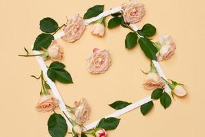 small white and pink flowers of a rose with green young leaves photo