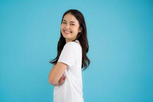 Beautiful Asian woman standing doing various poses on a blue background. photo