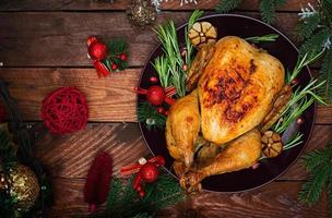 pavo o pollo al horno. la mesa navideña se sirve con un pavo, decorado con oropel brillante y velas. pollo frito, mesa. cena de Navidad. endecha plana vista superior foto