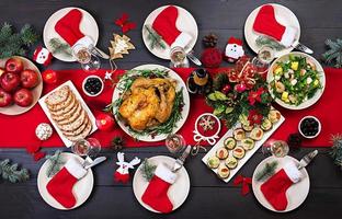 Baked turkey. Christmas dinner. The Christmas table is served with a turkey, decorated with bright tinsel and candles. Fried chicken, table.  Family dinner. Top view photo