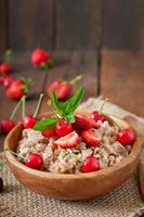 Oatmeal porridge with berries in a white bowl photo