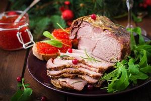 jamón al horno de navidad y caviar rojo, servido en la vieja mesa de madera. foto