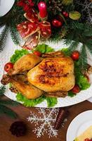 Baked turkey or chicken. The Christmas table is served with a turkey, decorated with bright tinsel and candles. Fried chicken, table. Christmas dinner. Flat lay. Top view photo