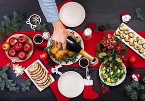 Baked turkey. Christmas dinner. The Christmas table is served with a turkey, decorated with bright tinsel and candles. Fried chicken, table.  Family dinner. Top view photo