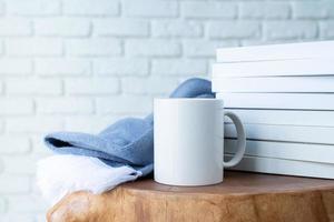 stack of white blank books for mockup and white mugs on wooden modern table photo
