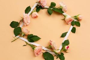 pequeñas flores blancas y rosadas de una rosa con hojas jóvenes verdes foto