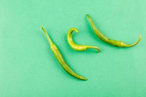 three small capsicum green hot chili peppers photo