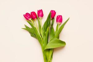 delicate bouquet of red tulips with green leaves photo