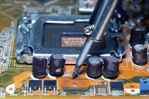 Repairman is soldering the motherboard of electronic device photo