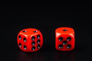 A pair of red dice on black background.close up view photo