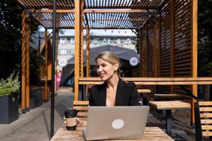 portrait of young successful woman with laptop outdoors photo