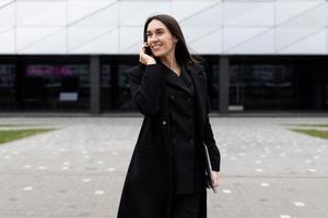 retrato de una fuerte mujer de negocios independiente con una laptop y un teléfono móvil en el contexto de una oficina moderna foto