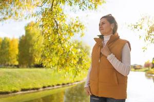 retrato de una chica fuerte en un parque de otoño junto a un estanque foto