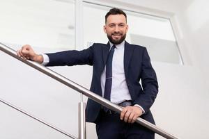 jefe presentable en un traje de negocios en la vista inferior de las escaleras, concepto de un líder empresarial exitoso foto