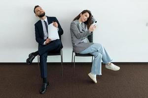 office employees sit on chairs man and woman waiting for an interview photo