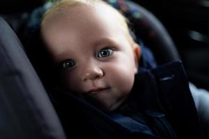 close-up portrait of a baby inside a car carrier photo