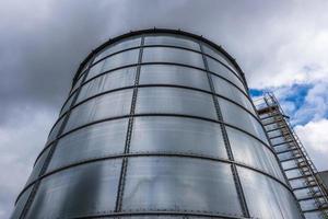 row of agro silos granary elevator with seeds cleaning line on agro-processing manufacturing plant for processing drying cleaning and storage of agricultural products photo