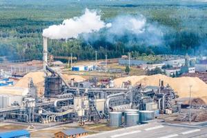 aerial view on pipes of woodworking enterprise plant sawmill. Air pollution concept. Industrial landscape environmental pollution waste photo