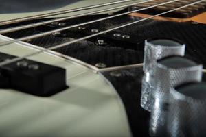 Close up guitar bass string details , four iron strings, white and black color photo