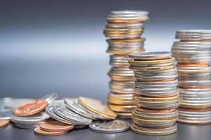 pila de monedas y monedas de montón en la mesa negra foto