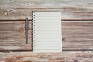 Top view image of notebook with pen on wooden table photo