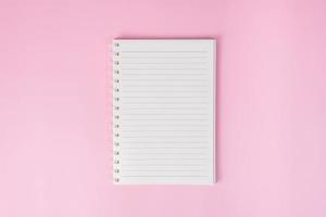 Top view image of notebook on pink background photo
