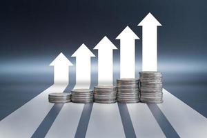 Stack of coins on black table with arrow graph growth up photo