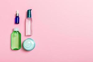 maqueta de marca de spa de cosméticos, vista superior con espacio de copia. conjunto de tubos y tarros de crema sobre fondo rosa foto