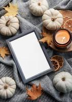 Autumn composition. Photo frame, pumpkins, dried leaves