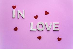 palabra de amor con letras de madera en el fondo rosa, día de san valentín foto