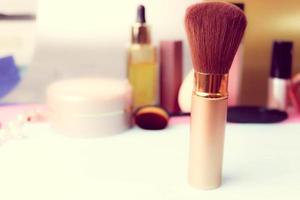 Gentle brush of natural lint for applying powder on the background of a cosmetic table for makeup for beauty guidance photo