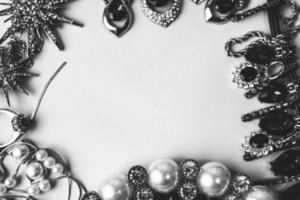 hermosas joyas preciosas y brillantes conjunto de joyas glamorosas de moda, collar, aretes, anillos, cadenas, broches con perlas y diamantes sobre un fondo blanco y negro. endecha plana, vista superior, lugar de copia foto